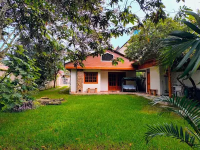 a house with an orange roof and a yard at Cabañas Típicas ARIAS in Oxapampa