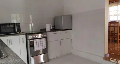 a kitchen with a stove and a microwave at Cabañas Típicas ARIAS in Oxapampa