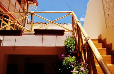 a balcony with two potted plants on a building at Casa De Mama Cusco - The Treehouse in Cusco