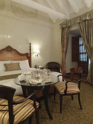 a bedroom with a bed and a table with glasses on it at Aranwa Cusco Boutique Hotel in Cusco