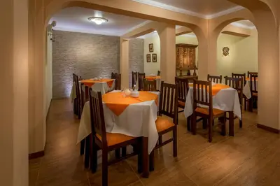 a dining room with tables and chairs in a restaurant at Katari Plaza Cusco El Virrey in Cusco
