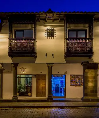 a building with balconies on a street at night at Katari Plaza Cusco El Virrey in Cusco