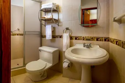 a bathroom with a white toilet and a sink at Katari Plaza Cusco El Virrey in Cusco