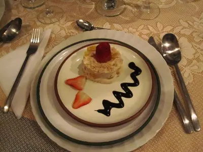 a plate with a piece of cake with a strawberry on it at Hostal Madre Tierra in Cusco