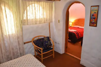 a bedroom with a bed and a chair in a room at Hostal Madre Tierra in Cusco