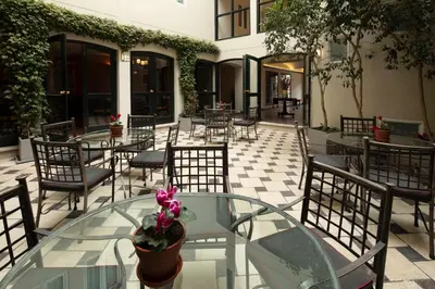 a glass table and chairs on a patio at LP Los Portales Hotel Cusco in Cusco