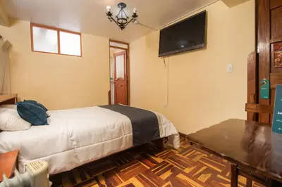 a bedroom with a bed and a flat screen tv at Ayenda Casa Escondida San Cristóbal Premium in Cusco