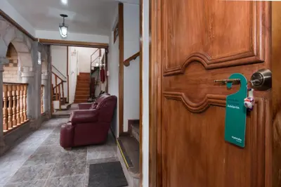 a door with a green sign on it in a hallway at Ayenda Casa Escondida San Cristóbal Premium in Cusco