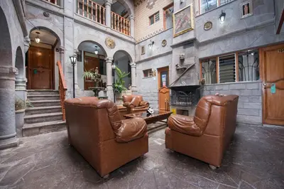 a living room with two chairs and a fireplace at Ayenda Casa Escondida San Cristóbal Premium in Cusco