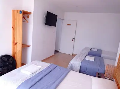 a bedroom with two beds and a flat screen tv at Paracas Guest House in Paracas