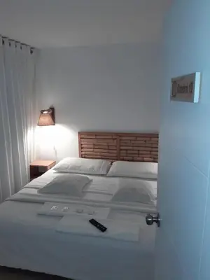 a bedroom with a bed with a remote control on it at Paracas Guest House in Paracas
