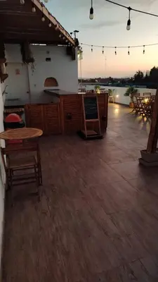 a patio with tables and a bar on a building at Paracas Guest House in Paracas