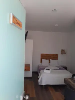 a bedroom with a bed with a white bedspread at Paracas Guest House in Paracas