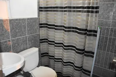 a bathroom with a toilet and a sink and a shower curtain at La Casa Maruja in Lima