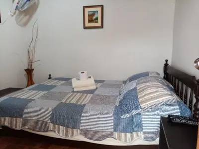 a bed with a blue and white blanket on it at La Casa Maruja in Lima