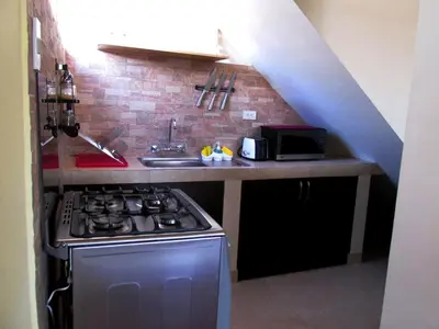 a kitchen with a stove and a sink and a staircase at Best View apartment downtown Cusco in Cusco