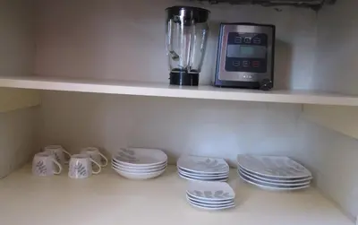 a shelf with cups and plates and a blender at Best View apartment downtown Cusco in Cusco