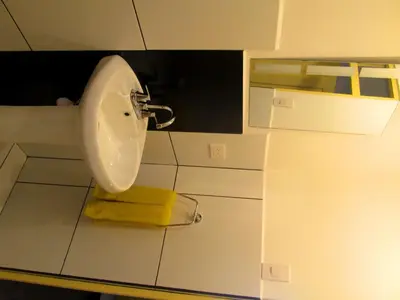 a bathroom with a white sink and a yellow towel at Best View apartment downtown Cusco in Cusco