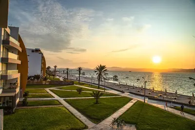 a view of the beach and the ocean at sunset at Condominio Nuevo Paracas in Paracas