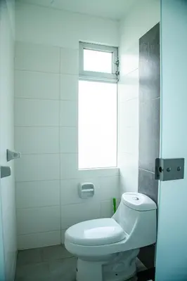 a bathroom with a white toilet and a window at Condominio Nuevo Paracas in Paracas