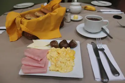 a table with a plate of breakfast food and a cup of coffee at Hotel Villa Urubamba in Urubamba