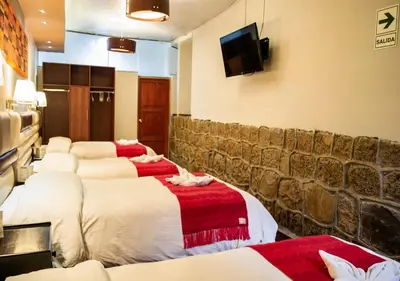a hotel room with four beds and a flat screen tv at Hotel Royal Qosqo in Cusco