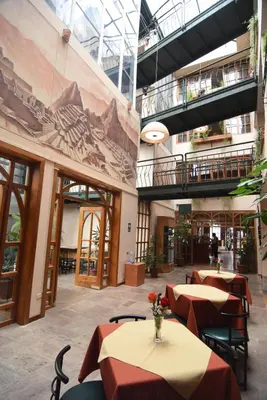 a restaurant with tables and chairs in a building at Hotel Prisma Cusco in Cusco
