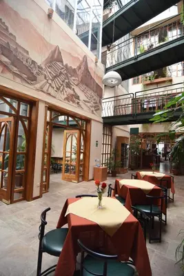 a restaurant with tables and chairs in a building at Hotel Prisma Cusco in Cusco