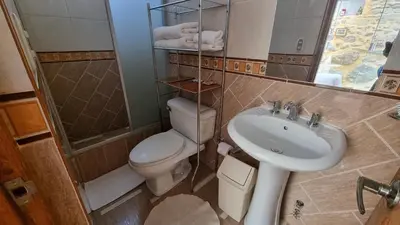 a bathroom with a toilet and a sink and a mirror at Ccapac Inka Ollanta Casa Museo in Ollantaytambo