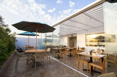 a restaurant with tables and chairs and an umbrella at Tierra Viva Miraflores Mendiburu in Lima