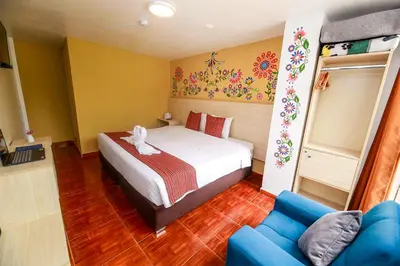 a bedroom with a bed and a blue couch at Mayu Boutique Hotel in Cusco