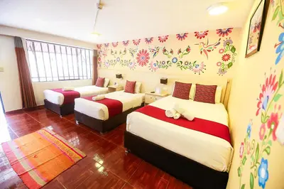 a bedroom with two beds and flowers on the wall at Mayu Boutique Hotel in Cusco
