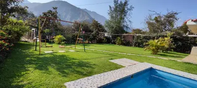 a backyard with a pool and a swing set at Casa de Campo Chinkay - Lunahuana in Lunahuaná