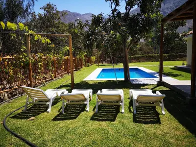 a group of chairs sitting next to a swimming pool at Casa de Campo Chinkay - Lunahuana in Lunahuaná