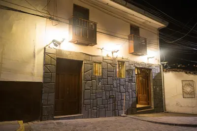 a building with lights on the side of it at night at Antawasi Hotel in Cusco