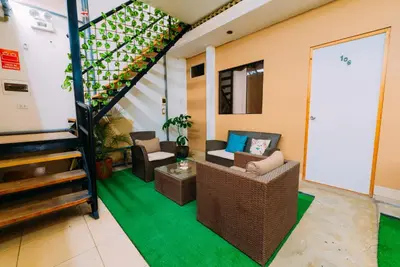 a living room with a couch and a staircase at Hospedaje Mary in Paracas