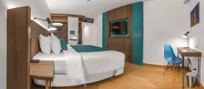 a hotel room with a bed and a desk and a television at Libre Hotel, BW Signature Collection by Best Western in Lima