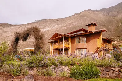 a house in the middle of a mountain at Inkasaire Boutique Lodge in Urubamba