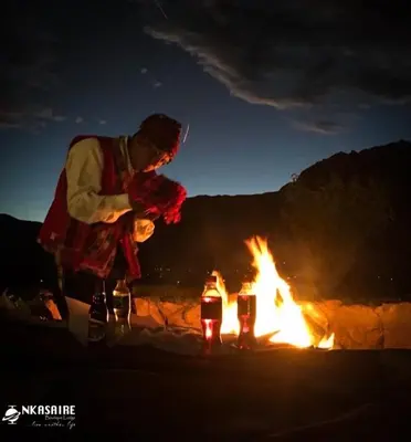 a man standing next to a fire at night at Inkasaire Boutique Lodge in Urubamba