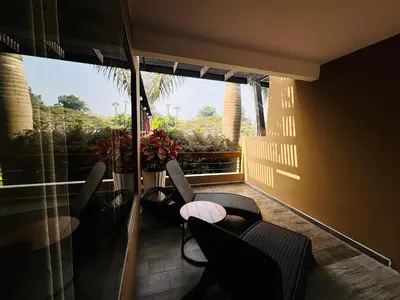 a room with a balcony with chairs and a window at Hotel Campo & Leña in Cieneguilla