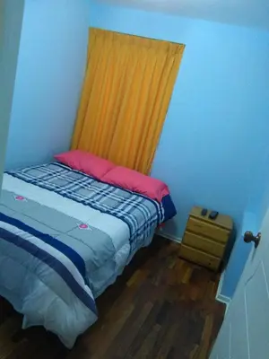 a bedroom with a bed with a yellow curtain at Mi casa es su casa in Lima