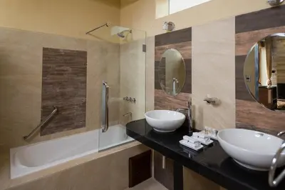 a bathroom with two sinks and a bath tub at Intiterra Apart Hotel Villas in Urubamba