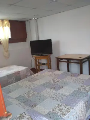 a bedroom with two beds and a flat screen tv at Hospedaje Marita in Lima