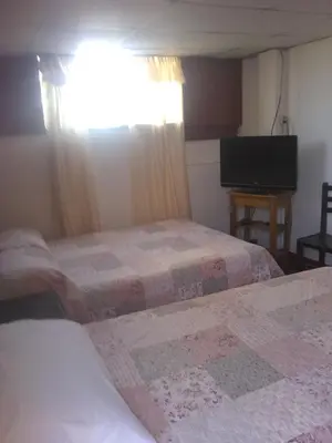 a hotel room with two beds and a flat screen tv at Hospedaje Marita in Lima