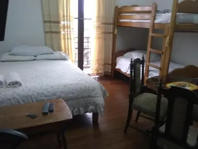 a bedroom with two bunk beds and a chair at Hospedaje Marita in Lima