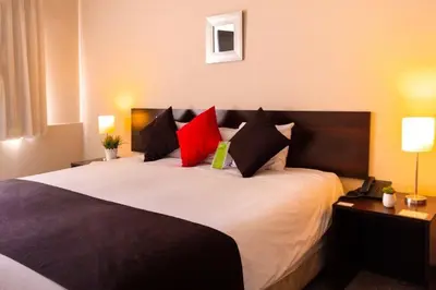 a bedroom with a large bed with red and black pillows at El Angolo in Lima