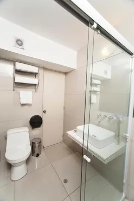 a white bathroom with a toilet and a sink at El Angolo in Lima