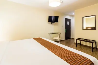 a hotel room with a bed and a table and a mirror at Tambo Dos de Mayo in Lima