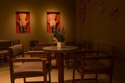 a dining room with tables and chairs and paintings at Tambo Dos de Mayo in Lima