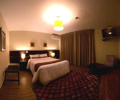 a hotel room with a large bed and a red rug at Tambo Dos de Mayo in Lima